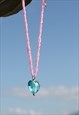 VINTAGE PINK BEADED NECKLACE WITH BLUE GLASS HEART PANDANT.
