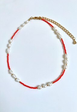 Orange beaded necklace with freshwater pearls.