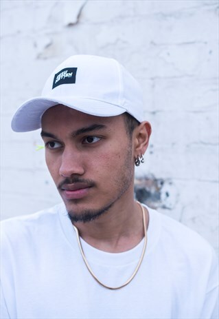 CAP IN WHITE WITH GREEN NEON TOGGLE AND EMBROIDERED PATCH.