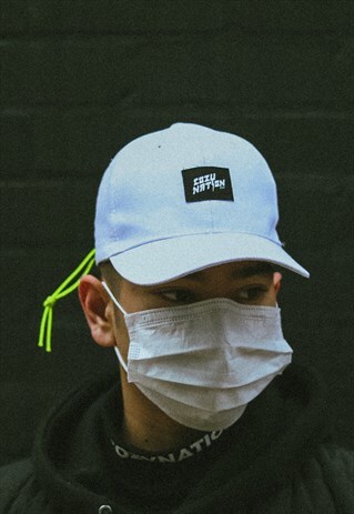 CAP IN WHITE WITH GREEN NEON TOGGLE AND EMBROIDERED PATCH.