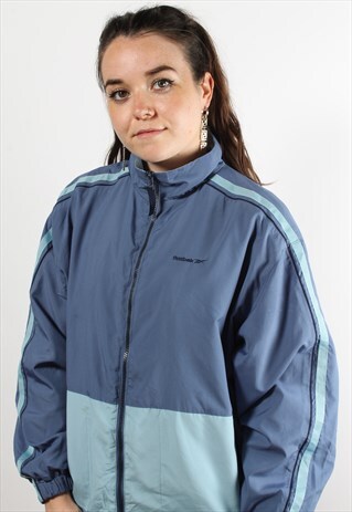 VINTAGE REEBOK WINDBREAKER JACKET IN BLUE W/ SPELL OUT LOGO
