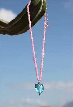 Vintage pink beaded necklace with blue glass heart pandant.